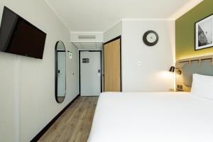a hotel room with a bed and a mirror at Campanile PRIME - Lublin in Lublin
