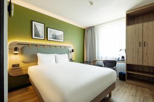 a hotel room with a large bed and a green wall at Campanile PRIME - Lublin in Lublin