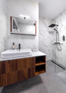 a bathroom with a sink and a shower at Evergreen Suites Budapest in Budapest