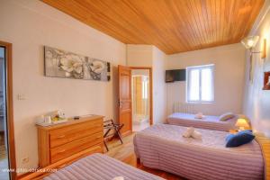 a bedroom with two beds and a wooden ceiling at U san larenzu in Aullène