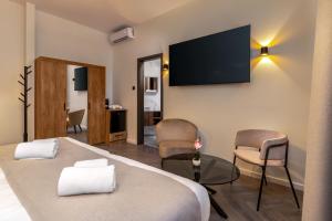 a hotel room with a bed and a tv on the wall at Evergreen Suites Budapest in Budapest