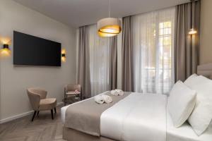 a hotel room with a bed and a tv at Evergreen Suites Budapest in Budapest