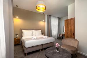 a hotel room with a bed and a chair at Evergreen Suites Budapest in Budapest