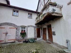 a white house with a balcony and a door at Apartment Mammut Loft in Balve