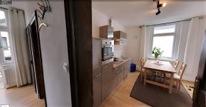 a kitchen and dining room with a table and a refrigerator at Apartment Mammut Loft in Balve