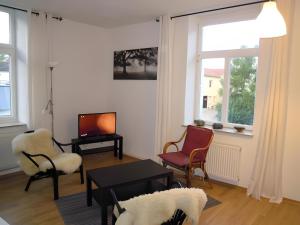 a living room with chairs and a table and a tv at Apartment Mammut Loft in Balve