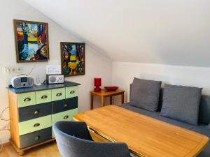 a bedroom with a bed and a dresser and a table at Klosterherberge Economy in Meßkirch