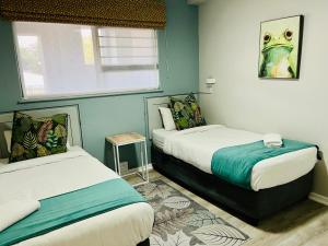 a bedroom with two beds and a frog painting on the wall at Hyde Park in Durban
