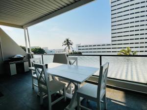 a table and chairs on a balcony with a view of the water at Hyde Park in Durban +36 photos