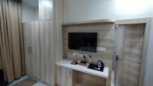 a room with a tv on a wall at Hotel SS Grand in Lucknow +15 photos