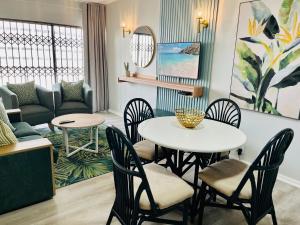 a room with a table and chairs and a couch at Hyde Park in Durban