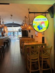 a restaurant with wooden tables and chairs and a sign at La Bourse in Bagnols-sur-Cèze