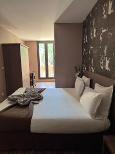 a bedroom with a large bed with white sheets and pillows at La Bourse in Bagnols-sur-Cèze