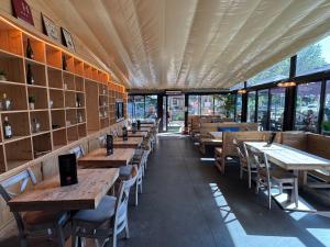 a restaurant with wooden tables and chairs and windows at La Bourse in Bagnols-sur-Cèze