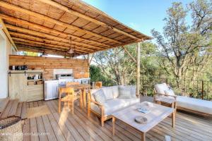 a patio with a couch and a table on a deck at Casa penisula in Porto-Vecchio