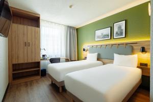 two beds in a hotel room with green walls at Campanile PRIME - Lublin in Lublin +39 photos