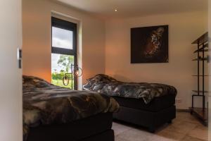 a bedroom with two beds and a window at De Hooiberg in Ritthem