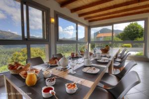 a dining room with a table and chairs and windows at Villa cardellini in Aullène