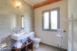 a bathroom with a sink and a toilet and a window at Villa cardellini in Aullène +19 photos