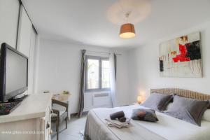 a bedroom with a bed with a desk and a television at Villa cardellini in Aullène
