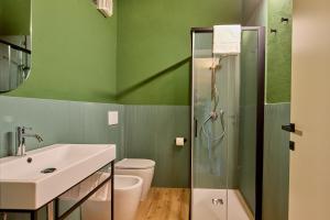 a green bathroom with a sink and a shower at AGRITURISMO RIPA DEL BOSCO in Capriolo