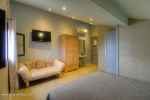 a living room with a couch and a tv on the wall at Couvent d'alando in Alando