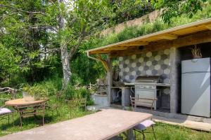 an outdoor kitchen with a picnic table and a grill at Couvent d'alando in Alando