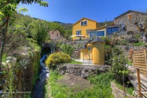 a house and a river in front of a house at Casa di l'apa in Venaco