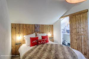 a bedroom with a large bed with red pillows at Casa di l'apa in Venaco