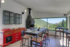 a kitchen with a table with chairs and a large window at Casa di l'apa in Venaco