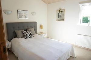 a bedroom with a large white bed and a window at 7000-Bogo-By-Mosedalen-6 in Bogø By