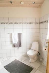a white bathroom with a toilet and a rug at 7000-Bogo-By-Mosedalen-6 in Bogø By +10 photos