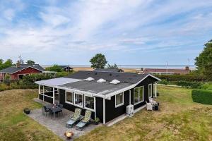 a black house with a roof on a yard at OH412-Hadsund-Halvrebene-94 in Hadsund