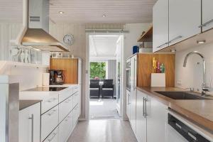 a kitchen with white cabinets and a dining room at OH412-Hadsund-Halvrebene-94 in Hadsund +12 photos