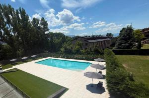a swimming pool with two umbrellas and a swimming pool at Hotel Llivia in Llivia