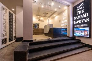 a lobby with stairs and a sign on the wall at The Namami Tapovan in Rishīkesh