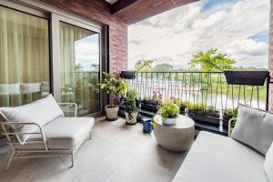a balcony with a couch and chairs and plants at Elbblick Premium-Apartment zentral in Dresden in Dresden