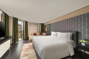 a large white bed in a hotel room at JingLai Bushe Hotel the Bund Nanjing West Road Shanghai in Shanghai +92 photos