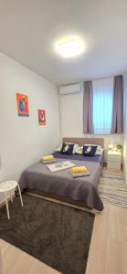 a bedroom with a large bed with blue sheets and yellow pillows at Guest House Jasna in Novalja