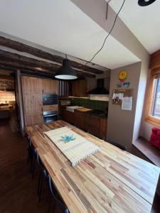 a kitchen with a wooden table in a room at Casa Robelca in Biescas