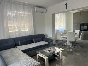 a living room with a blue couch and a table at Apartment CReO Loborika in Marčana