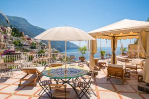 a patio with chairs and a table and umbrella at Florida Residence in Positano