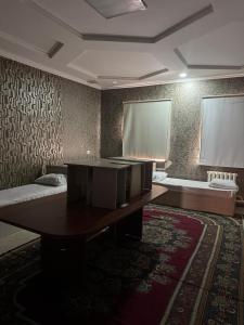 a room with a table and two beds in it at SaYAHAT TIMES in Türkistan
