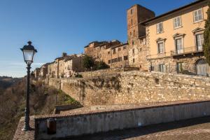a street light next to a wall with buildings at WhiteHouse in Colle Val D'Elsa