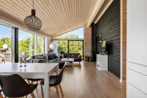 a dining room and living room with a table and chairs at S749-Stroby-Nattergalevej-9 in Strøby