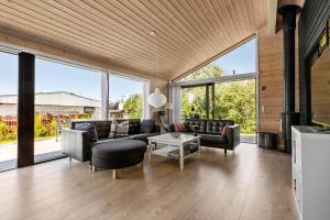 a living room with furniture and large windows at S749-Stroby-Nattergalevej-9 in Strøby +11 photos