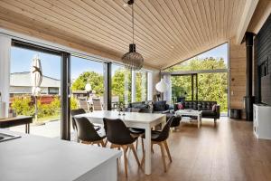a kitchen and living room with a table and chairs at S749-Stroby-Nattergalevej-9 in Strøby