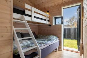 a tiny house with a bunk bed and a ladder at S749-Stroby-Nattergalevej-9 in Strøby