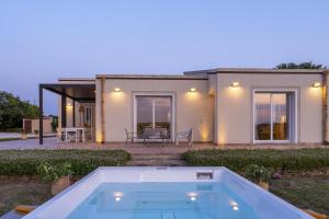 a house with a swimming pool in front of it at Villa Lumiere in Modica
