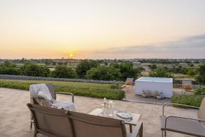 a patio with a table and chairs and the sunset at Villa Lumiere in Modica
